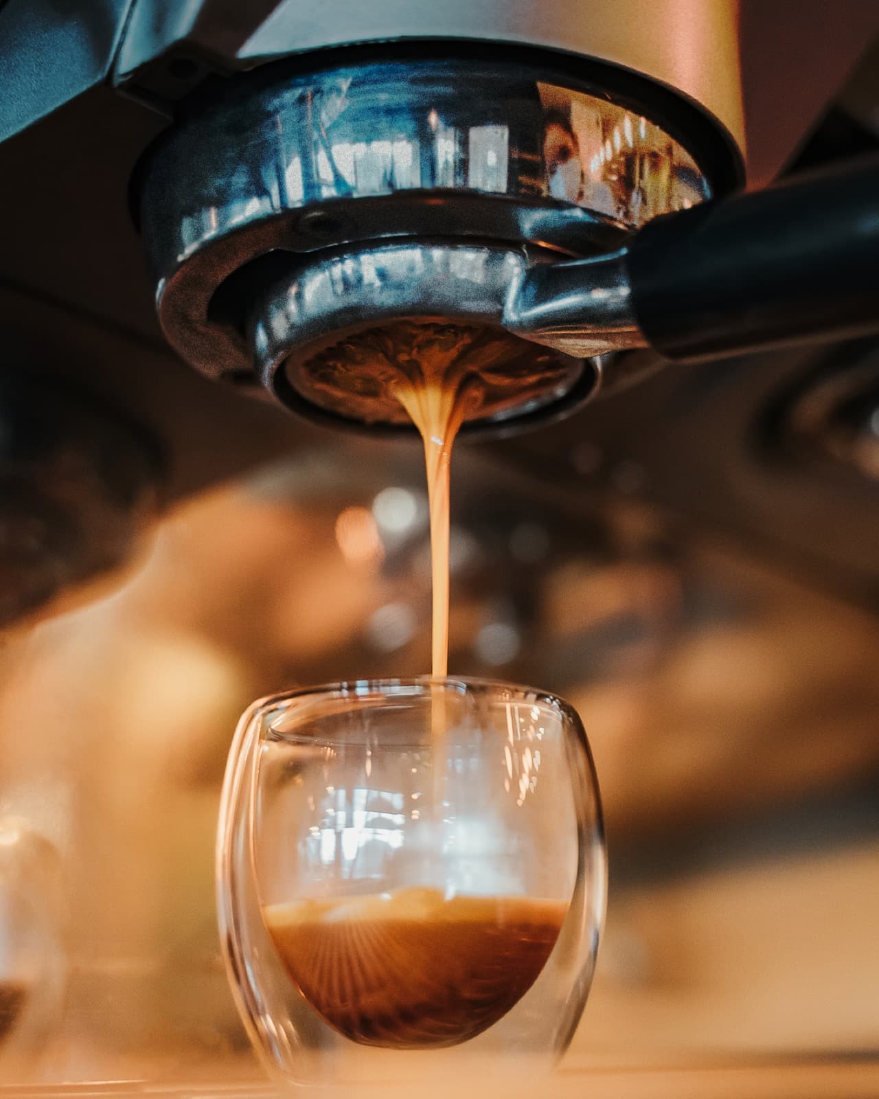 Extracción de espresso a un vaso de cristal